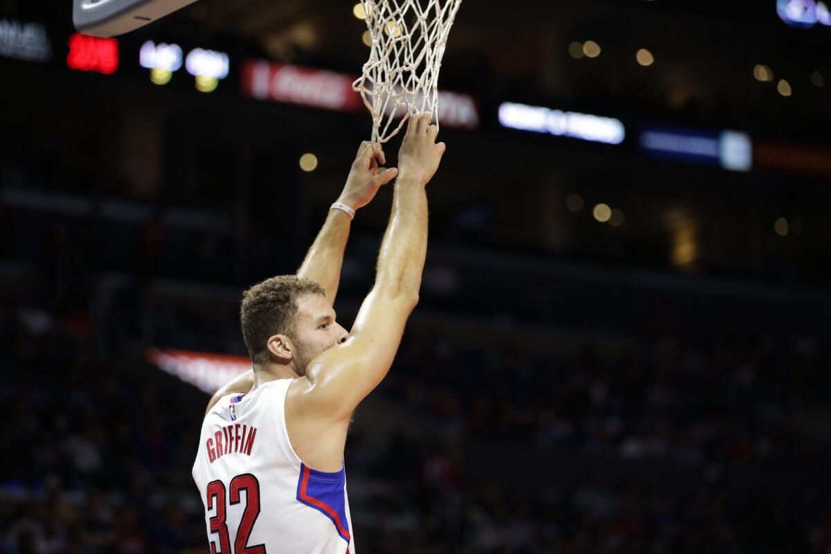 The Clippers' Blake Griffin tugs on the net during the second half of an NBA preseason game against the Golden State Warriors on Oct. 20, 2015, at Staples Center.