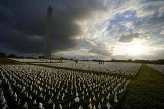 FILE - With the Washington Monument in the background, people look at white flags that are part of artist Suzanne Brennan Firstenberg's temporary art installation, "In America: Remember," in remembrance of Americans who have died of COVID-19, on the National Mall in Washington, Sept. 17, 2021. The installation consists of more than 630,000 flags. The federal government has provided more than $2 billion to help cover funeral costs for more than 300,000 families of people who died from COVID-19, the Federal Emergency Management Agency announced Tuesday as launches a new campaign to raise awareness for the aid to the families of the more than 965,000 people who have died in the U.S. from the virus. (AP Photo/Brynn Anderson, File)