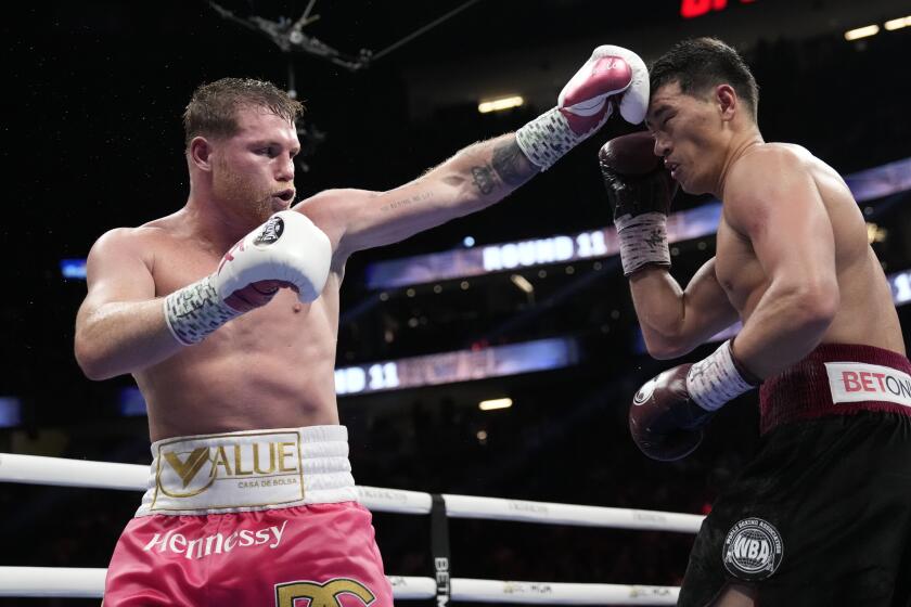 Canelo Alvarez, left, of Mexico, throws a punch against Dmitry Bivol.