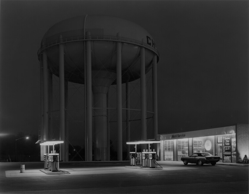 An artistic shot of a gas station at night with a car