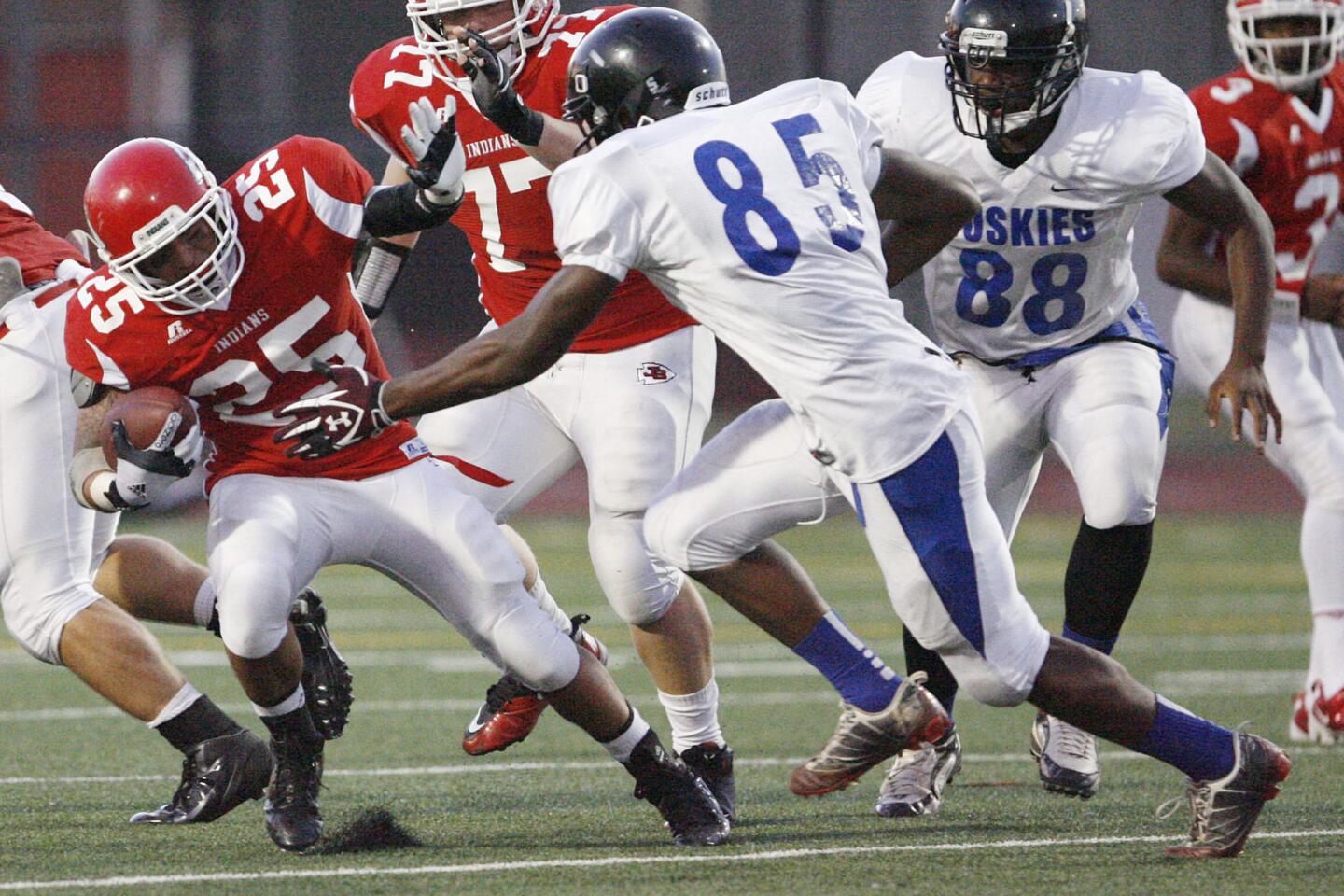 Burroughs' Israel Montes, left, is tackled by North Hollywood during a game at John Burroughs High School in Burbank on Friday, September 7, 2012.