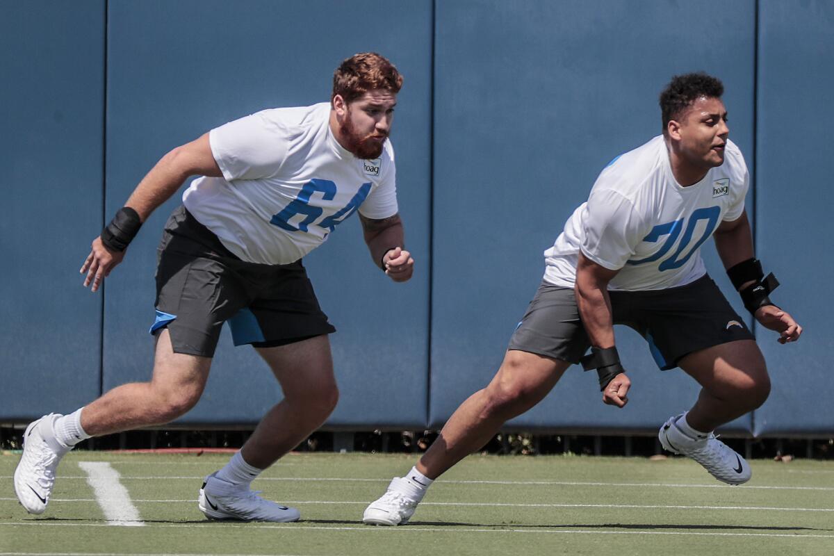 Chargers lineman Brenden Jaimes (64) and tackle Rashawn Slater work out during rookies minicamp.