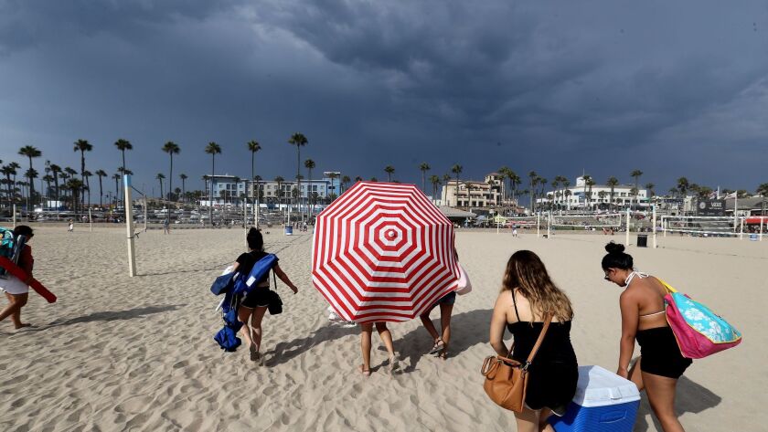 People evacuate Huntington Beach as a thunderstorm with potential for lightning approached the area.