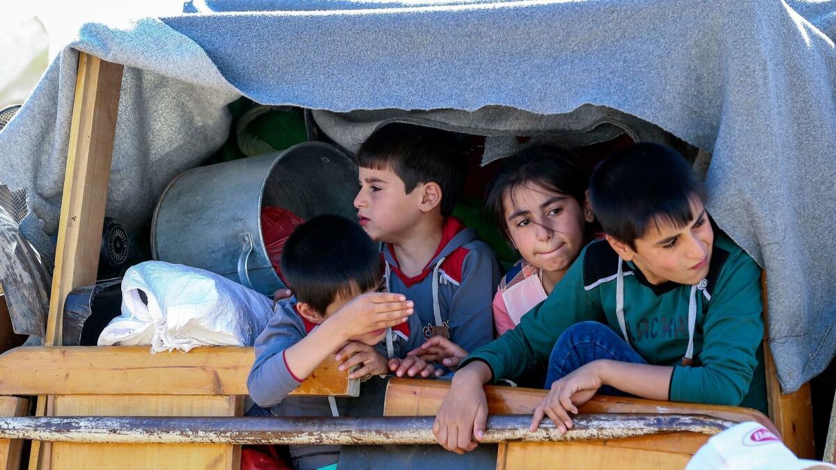 Syrian refugees sit in their car waiting to be evacuated from a camp in the border town of Arsal, Lebanon.