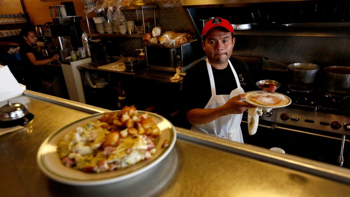 Jesus Matias, an employee for nine years, prepares dishes at Nickel Diner in downtown Los Angeles. The diner's owners worry about the impact of a $12 minimum wage.