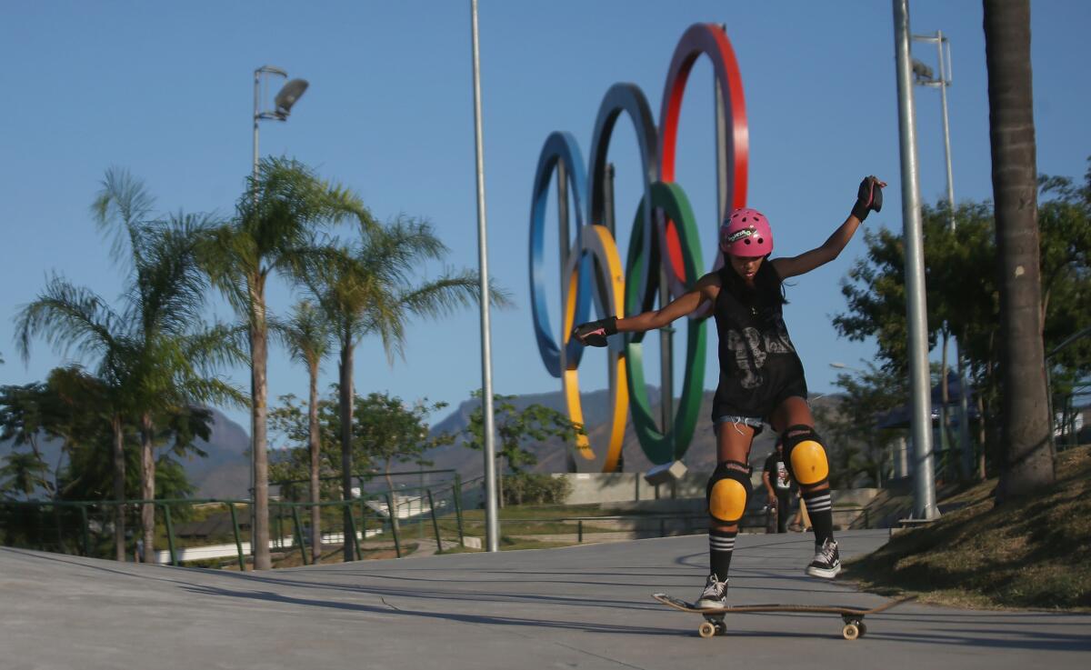 A girl skateboards in front of the Olympic Rings on Aug. 11 in Rio de Janeiro.