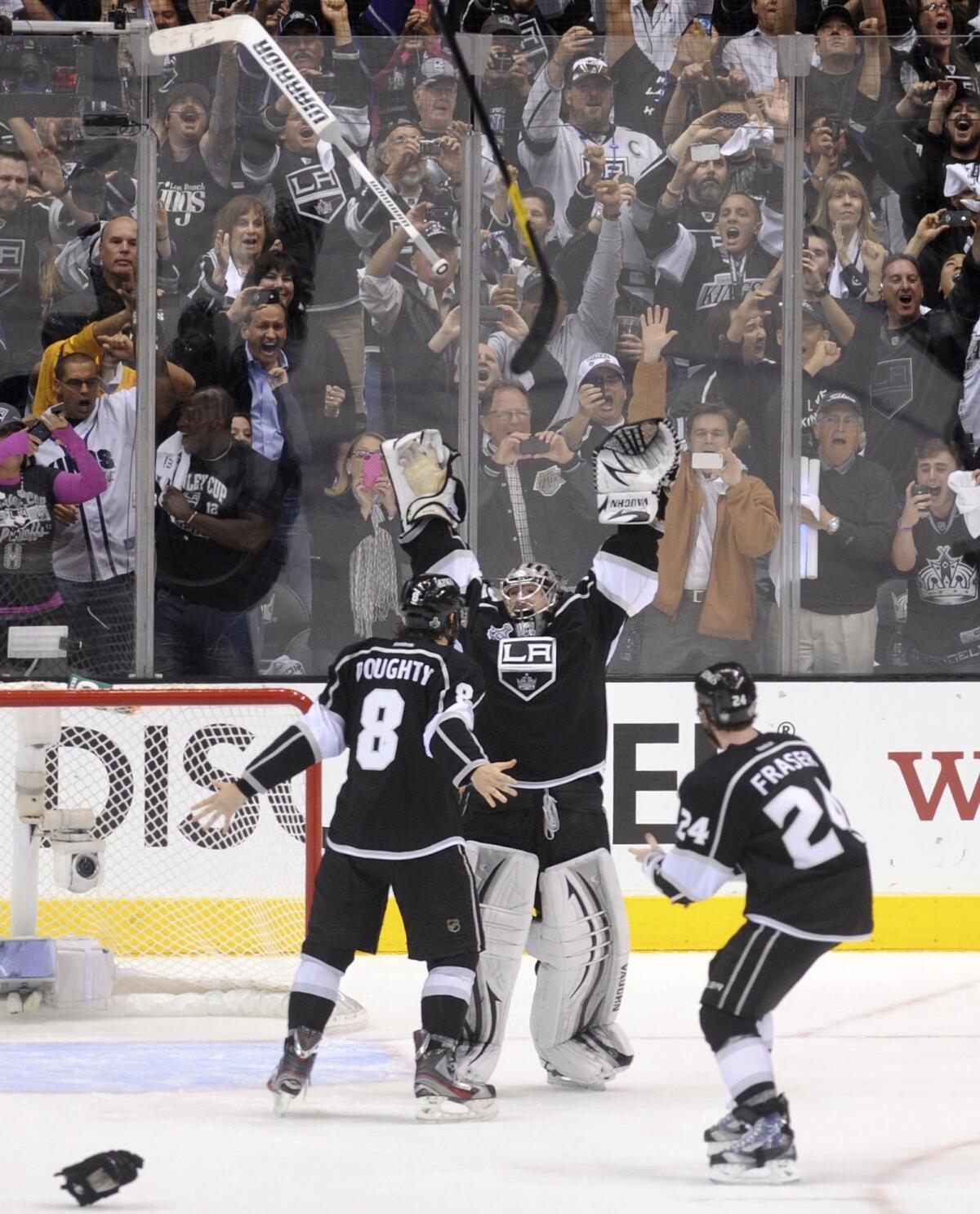 Jonathan Quick throws up his hands as he celebrates with Drew Doughty and Colin Fraser. 