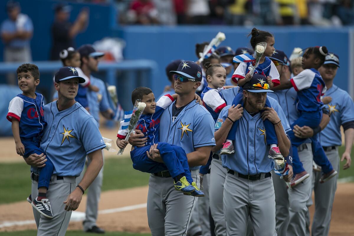 Tampa Bay Rays players carry Cuban children during opening ceremonies at an exhibition baseball game between wiith the Cuban National Team.