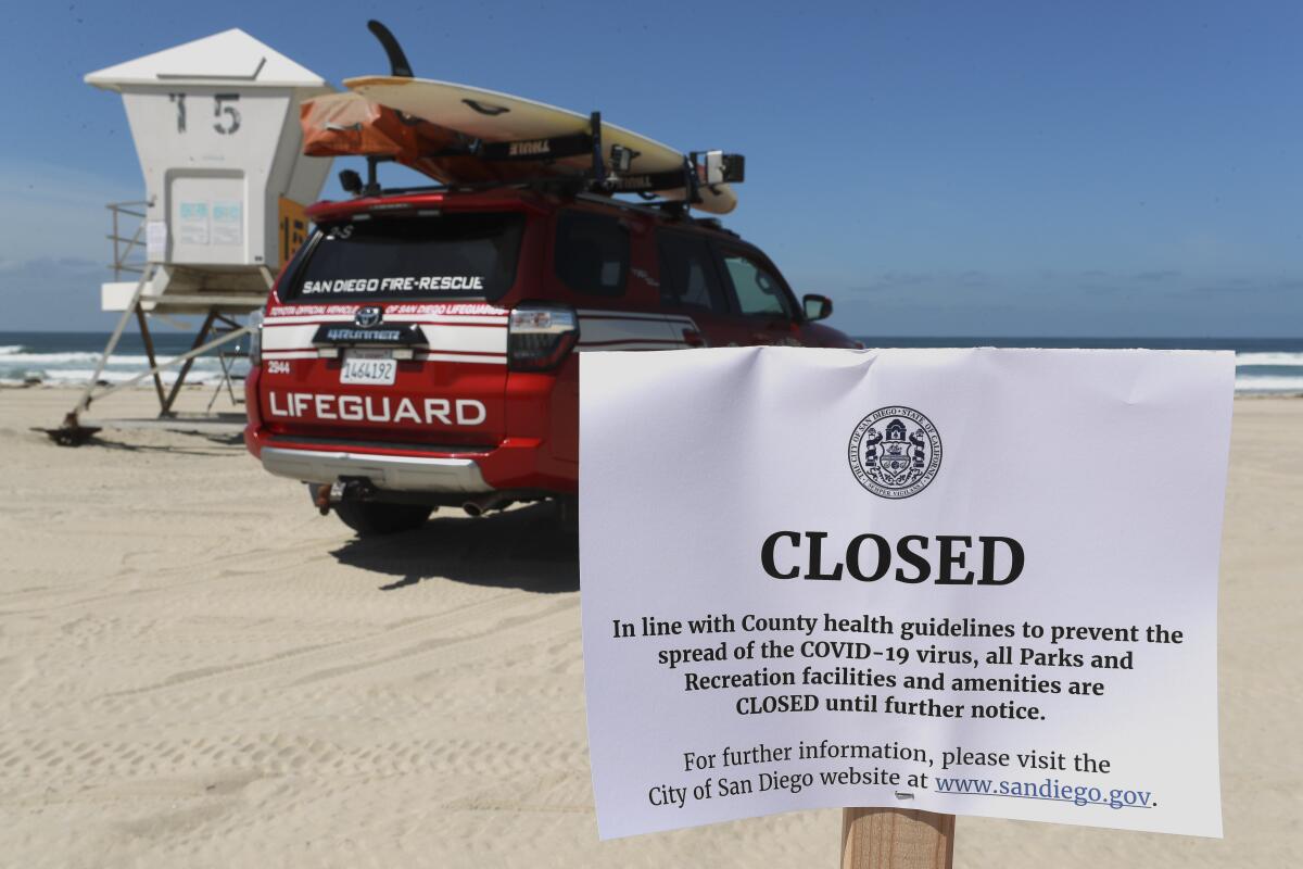 Signs are posted on March 28, 2020, at Mission Beach in San Diego, which is closed because of the coronavirus outbreak.