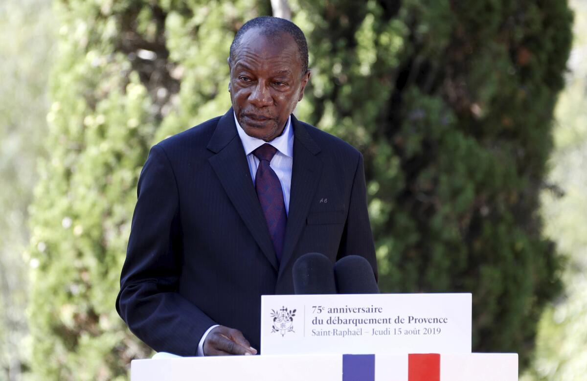 Alpha Conde speaks outdoors at a lectern.