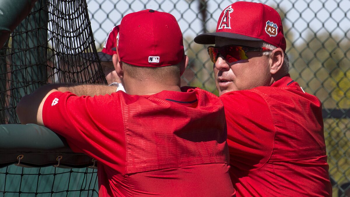 Angels Manager Mike Scioscia chats with outfielder Mike Trout during a batting practice this spring.