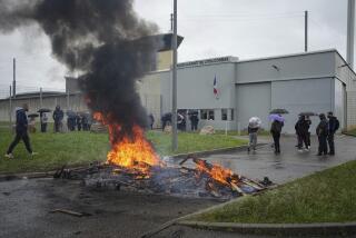 Prison workers gather during a protest outside the Corbas prison, outside Lyon, France, Wednesday, May 15, 2024 . A massive manhunt was underway in France on Wednesday for an armed gang that ambushed a prison convoy, killing two prison officers, seriously injuring three others and springing the inmate they were escorting. (AP Photo/Laurent Cirpiani)