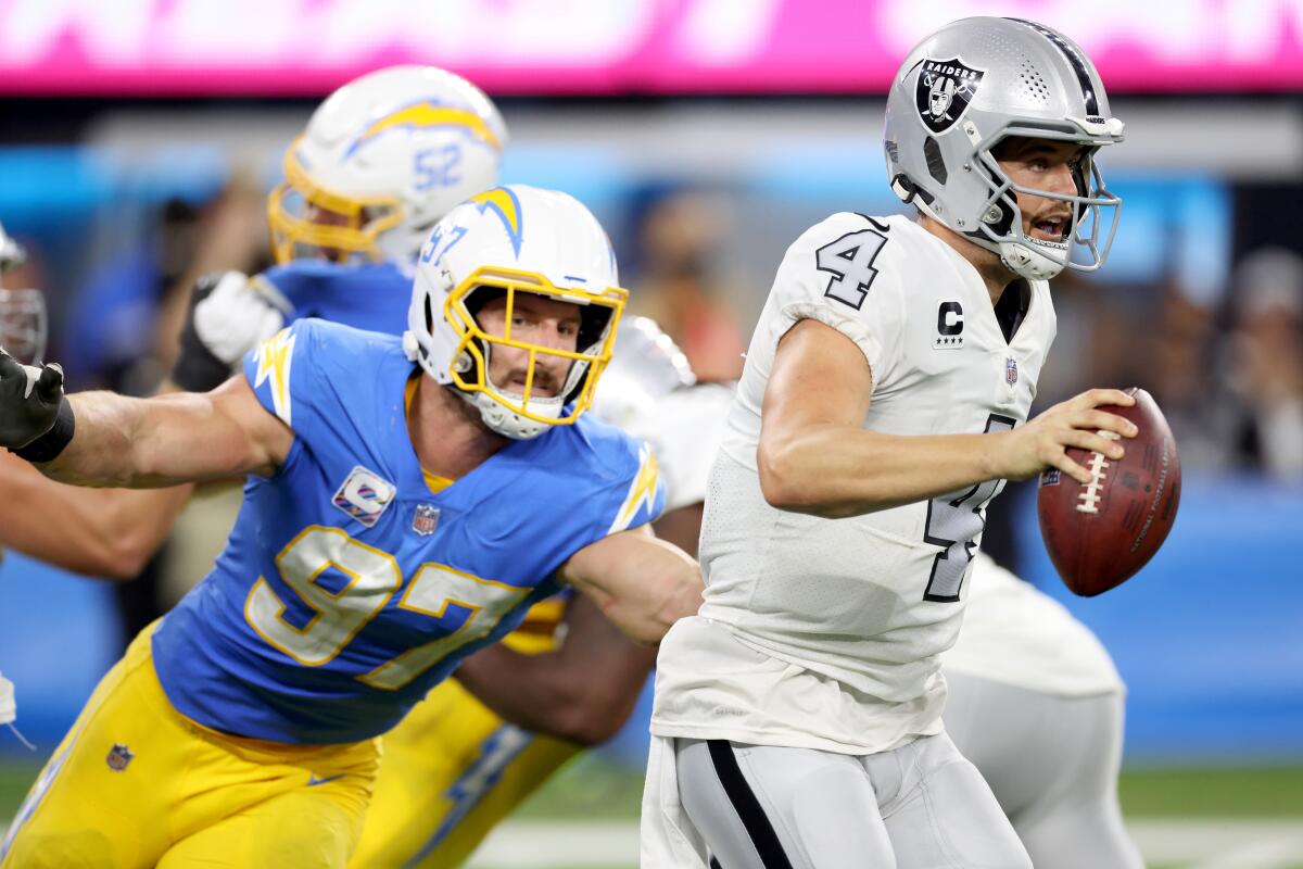 Las Vegas Raiders quarterback Derek Carr tries to scramble away from Chargers linebacker Joey Bosa.