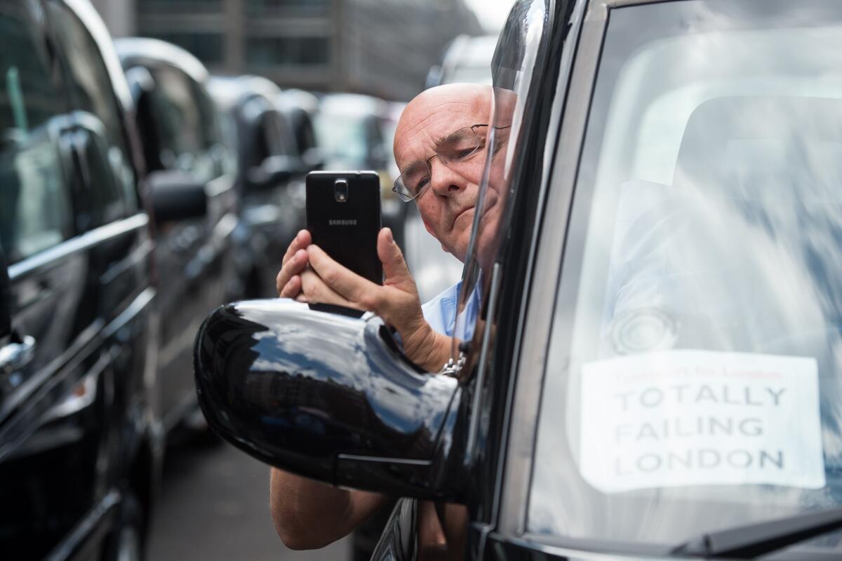 Taxi drivers take part in a demonstration in central London on May 26 against mobile app Uber and regulator Transport for London (TFL).