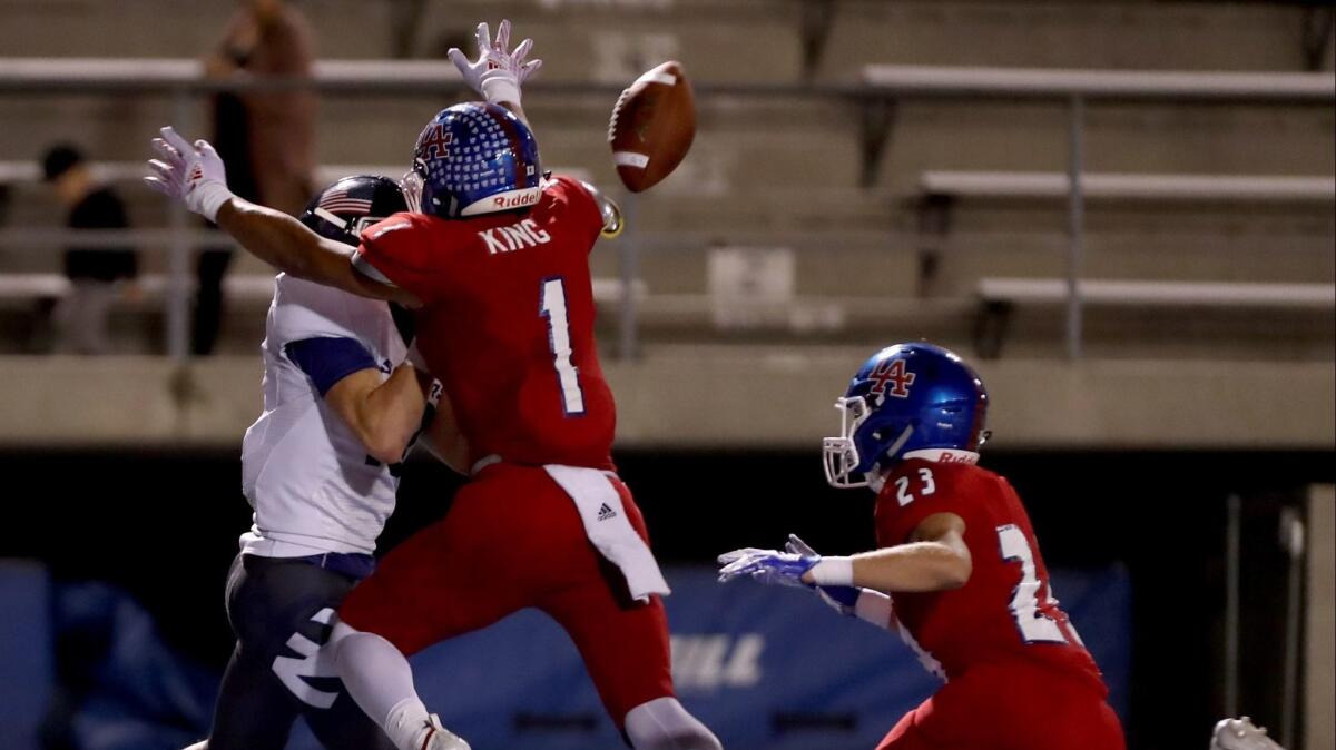 Newport Harbor High wide receiver Aidan Goltz, left, is smothered and denied a touchdown by Los Alamitos' Demario King, center, as Nathan Kersey, right, comes in to help in a Sunset League game on Friday.