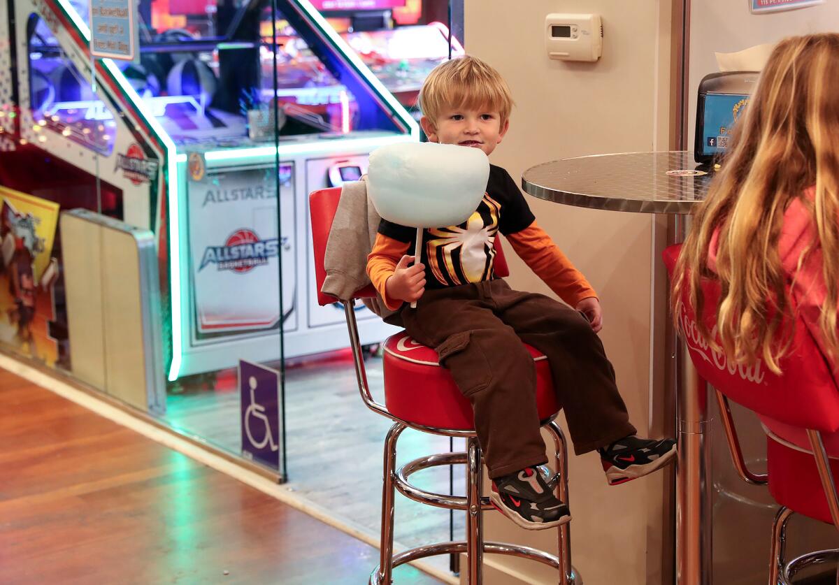 Noah Lane enjoys cotton candy at the Yummy Dogs Gourmet Hot Dogs and Arcade during Hospitality Night in Laguna Beach.