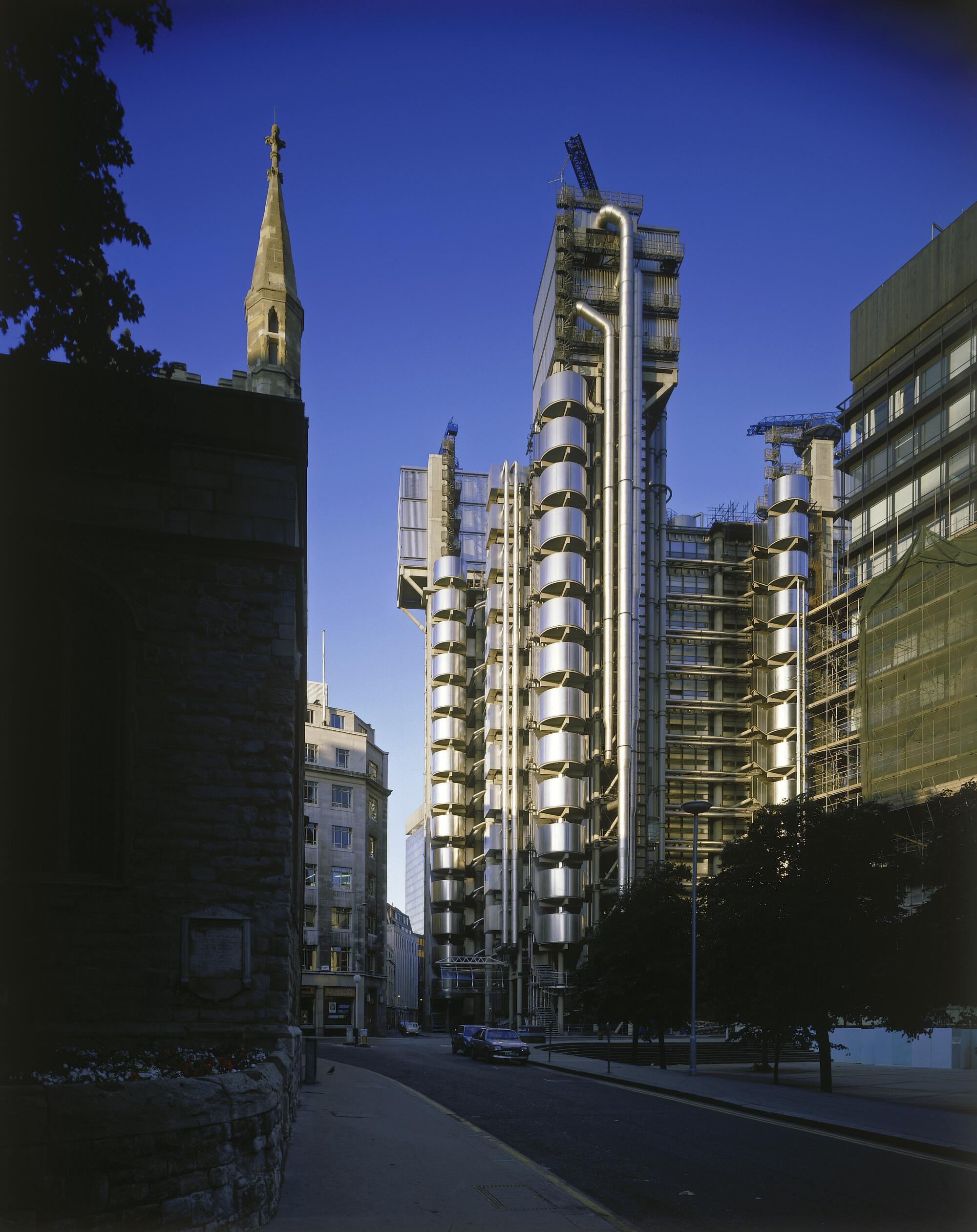 The mechanical forms of the Lloyd's of London building, looking like sparkly silver loops, rise above a narrow lane