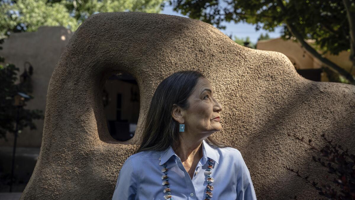 Interior Secretary Deb Haaland poses for a photo in front of a rock formation