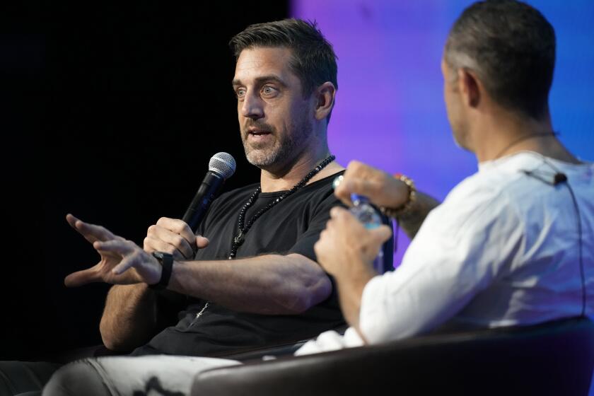 New York Jets quarterback Aaron Rodgers, back, chats with entrepreneur Aubrey Marcus.