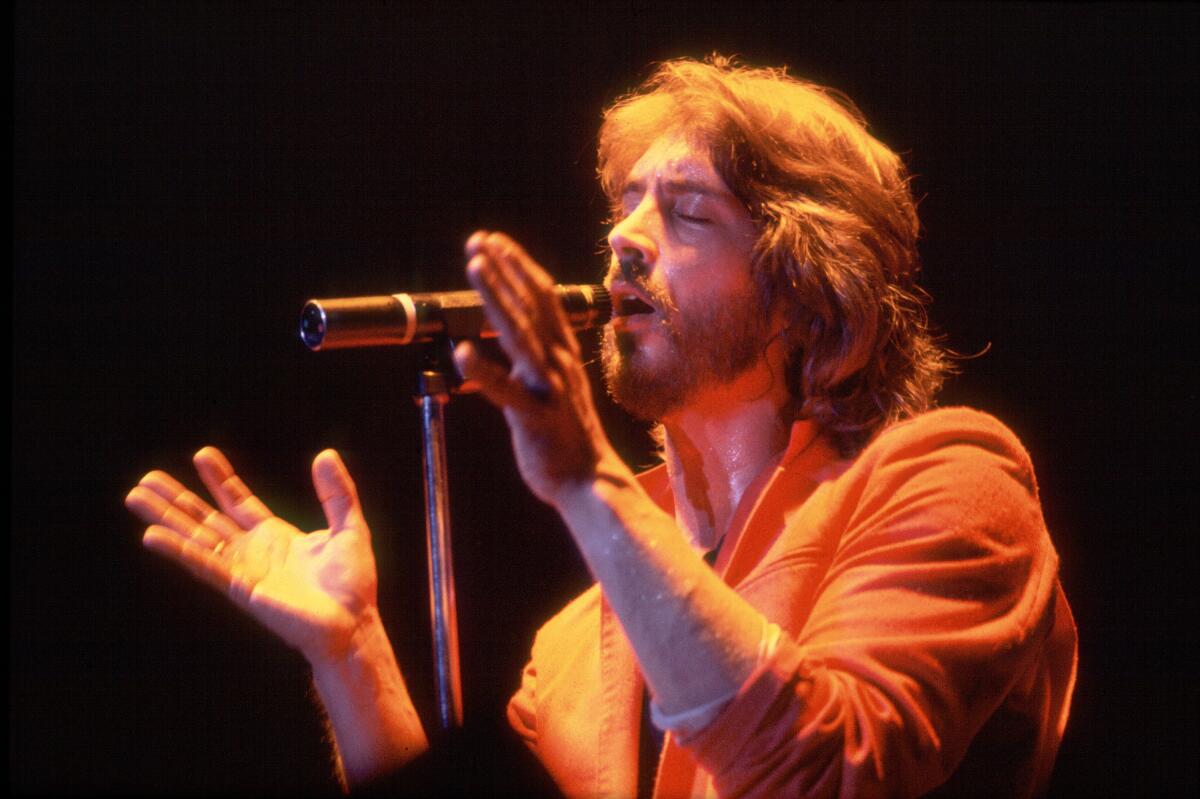 Singer and guitarist Michael Stanley sings at a microphone