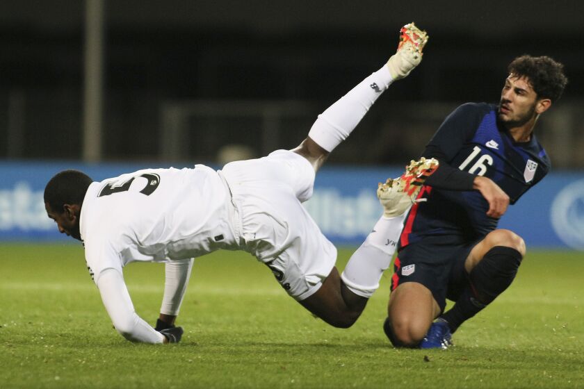 Panama's Abdiel Ayarza falls as he is tackled by United States' Johnny Cardoso during the international friendly soccer match between the USA and Panama at the SC Wiener Neustadt stadium in Wiener Neustadt, Austria, Monday, Nov. 16, 2020. (AP Photo/Ronald Zak)