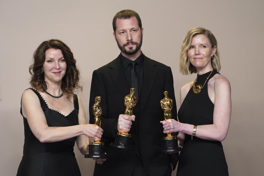 Raney Aronson-Rath, de izquierda a derecha, Mstyslav Chernov, y Michelle Mizner posan en la sala de prensa con el premio a mejor largometraje documetnal por "20 Days in Mariupol" en los Oscar el domingo 10 de marzo de 2024, en el Teatro Dolby en Los Ángeles. (Foto Jordan Strauss/Invision/AP)