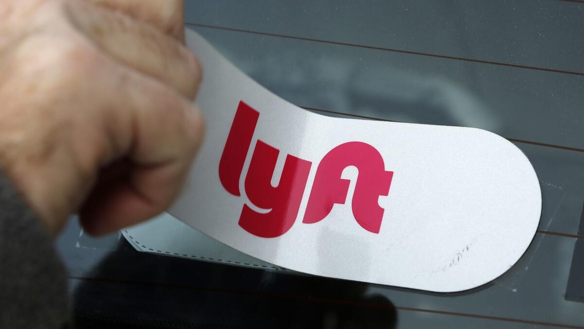 A Lyft logo is installed on a car in 2018.