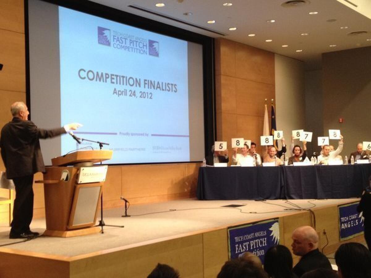 Judges hold up presentation scores for start-up Essio at Tech Coast Angels' Fast Pitch Competition at UCLA.