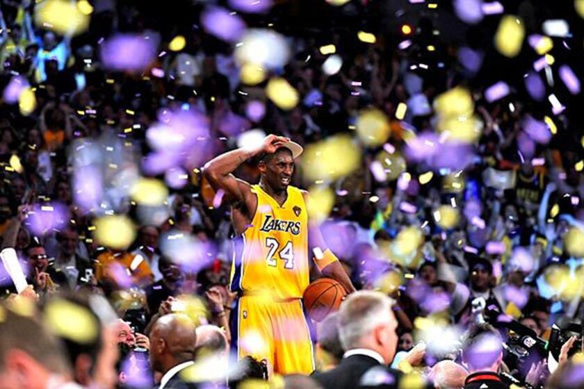 Kobe Bryant stands on the scorers' table at Staples Center after the Lakers defeated the Celtics to win the NBA championship on Thursday night at Staples Center.