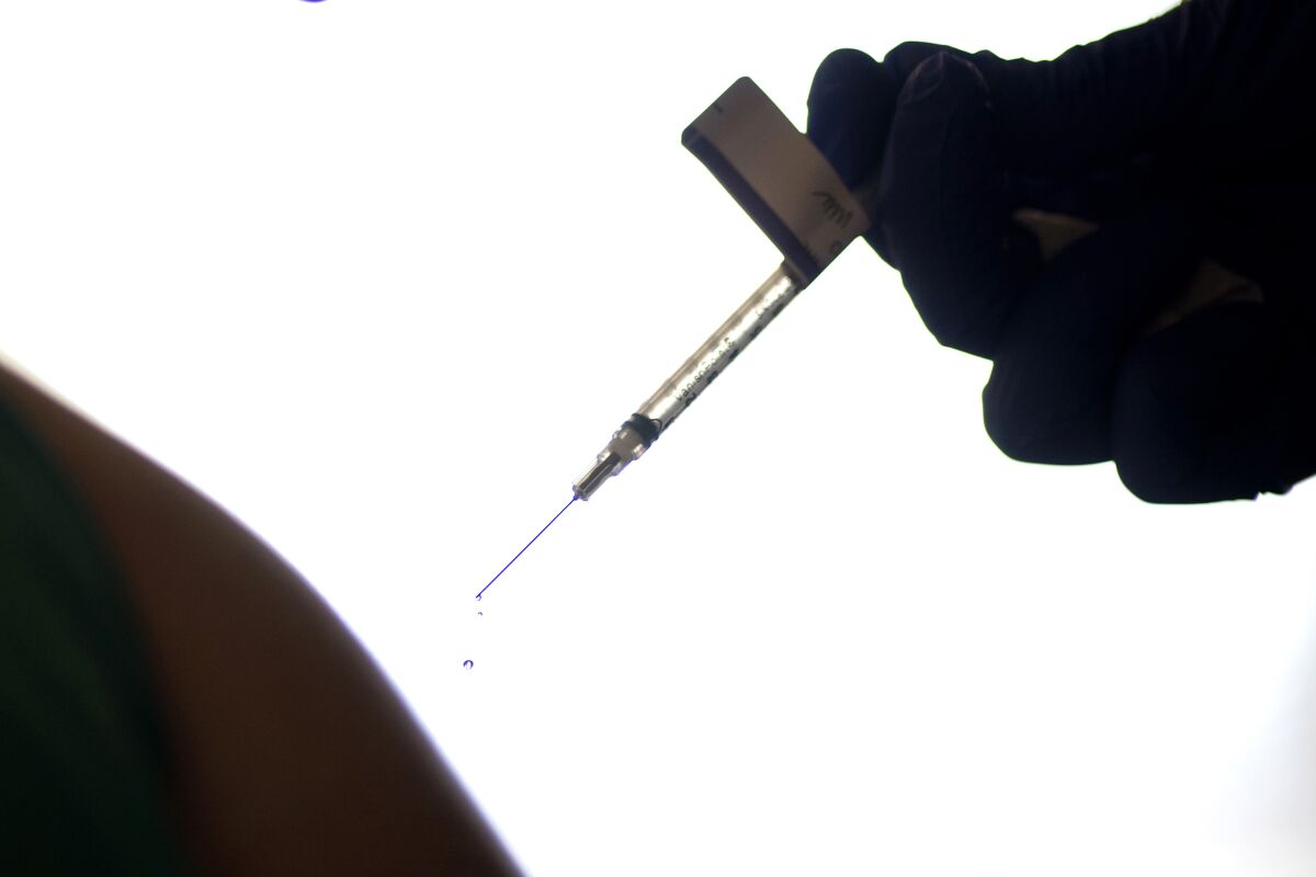 FILE - A droplet falls from a syringe after a health care worker was injected with the Pfizer-BioNTech COVID-19 vaccine at Women & Infants Hospital in Providence, R.I., on Dec. 15, 2020. On Friday, June 10, 2022, The Associated Press reported on stories circulating online incorrectly claiming that 20,000 people have died from COVID-19 vaccines. The figure misrepresents data maintained by the Centers for Disease Control and Prevention and the Food and Drug Administration. To date, a total of nine deaths in the U.S. have been linked to the shots. (AP Photo/David Goldman, File)