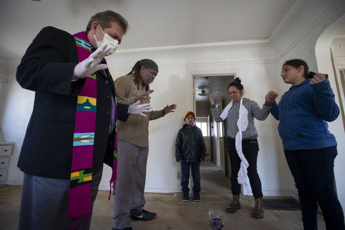 Protesters and their supporters pray inside of a home in El Sereno on Wednesday. 
