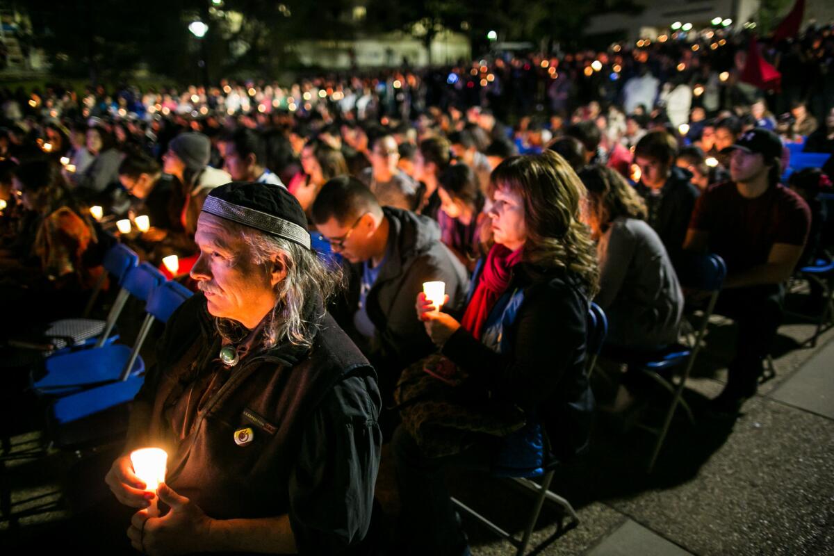 Community members and students at CSU San Bernardino light and hold their candles as they attend a vigil for the victims of the deadly San Bernardino terrorist attack.