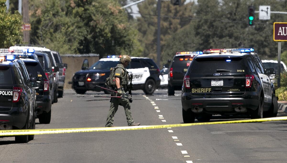 Law enforcement officers, including this Sacramento County sheriff's deputy, surround a hotel in Sacramento on Wednesday.