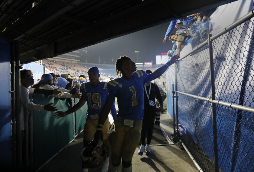 Dorian Thompson-Robinson (1) reaches out to fans as he heads to the locker room after a disappointing loss to Fresno State.