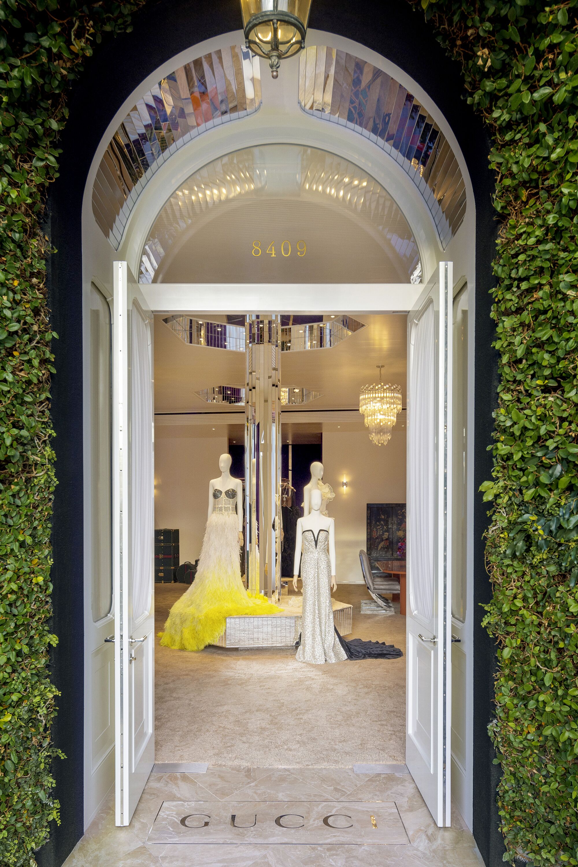 A view of dresses on mannequins through an open door.