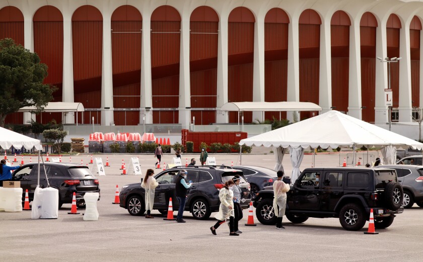 People in medical gear and vehicles outside the Forum.