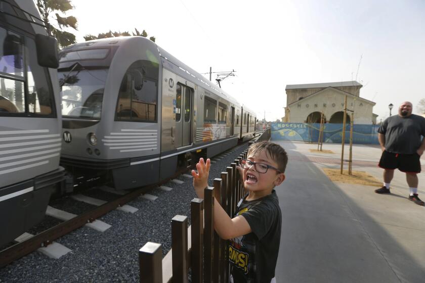 Train lover Joshua Cota, 6, of Baldwin Park, waves as the new Metro Gold Line extension passes by during testing at the new Monrovia Station Square on March 2.