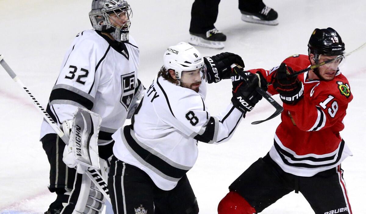 Kings defenseman Drew Doughty (8) and Blackhawks center Jonathan Toews (19) get into a pushing match in front of goalie Jonathan Quick (32) during the first period of Game 2 on Wednesday in Chicago.