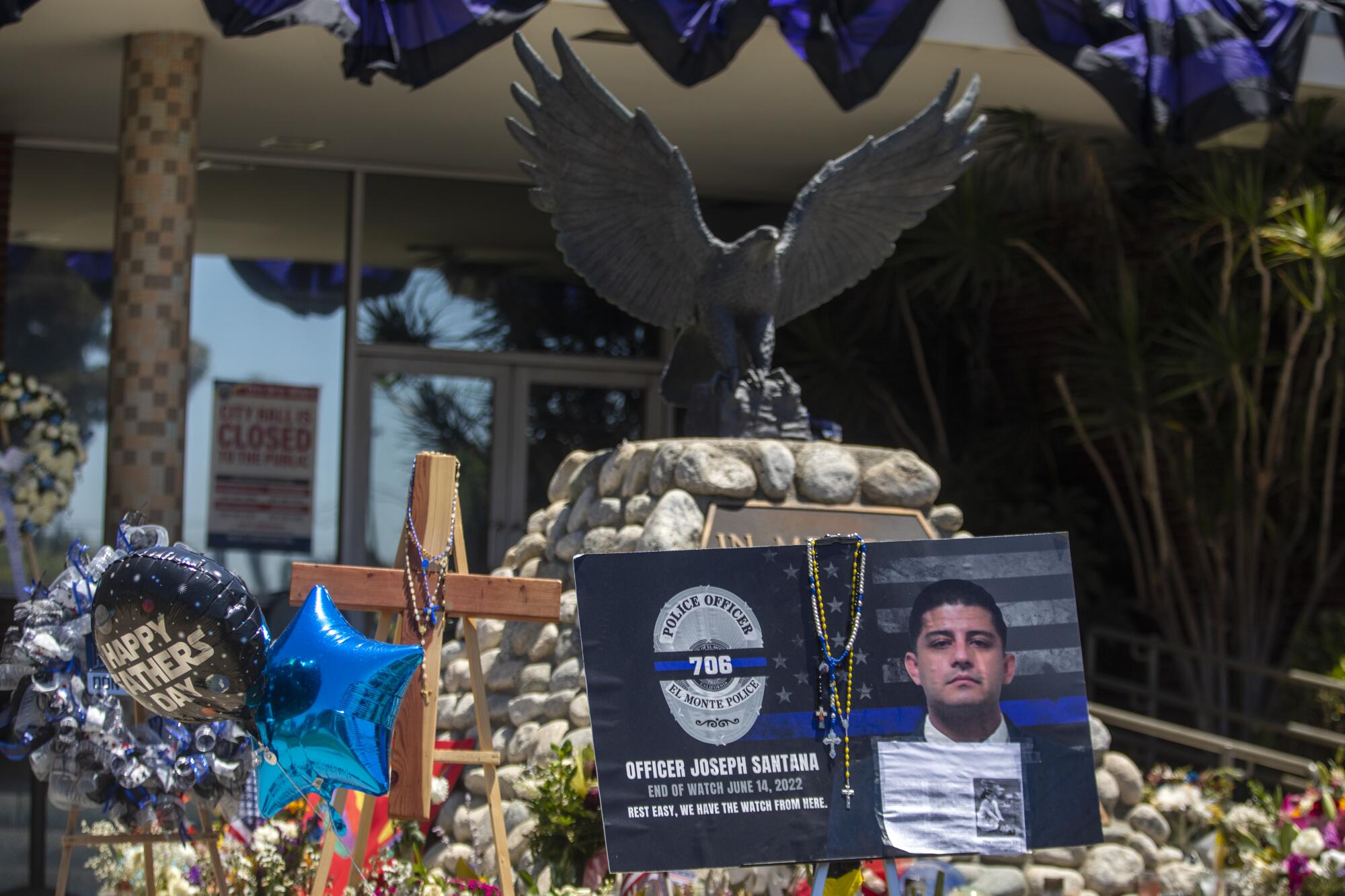 People continue to drop by El Monte Police Department headquarters and look at flowers, flags, and balloons 