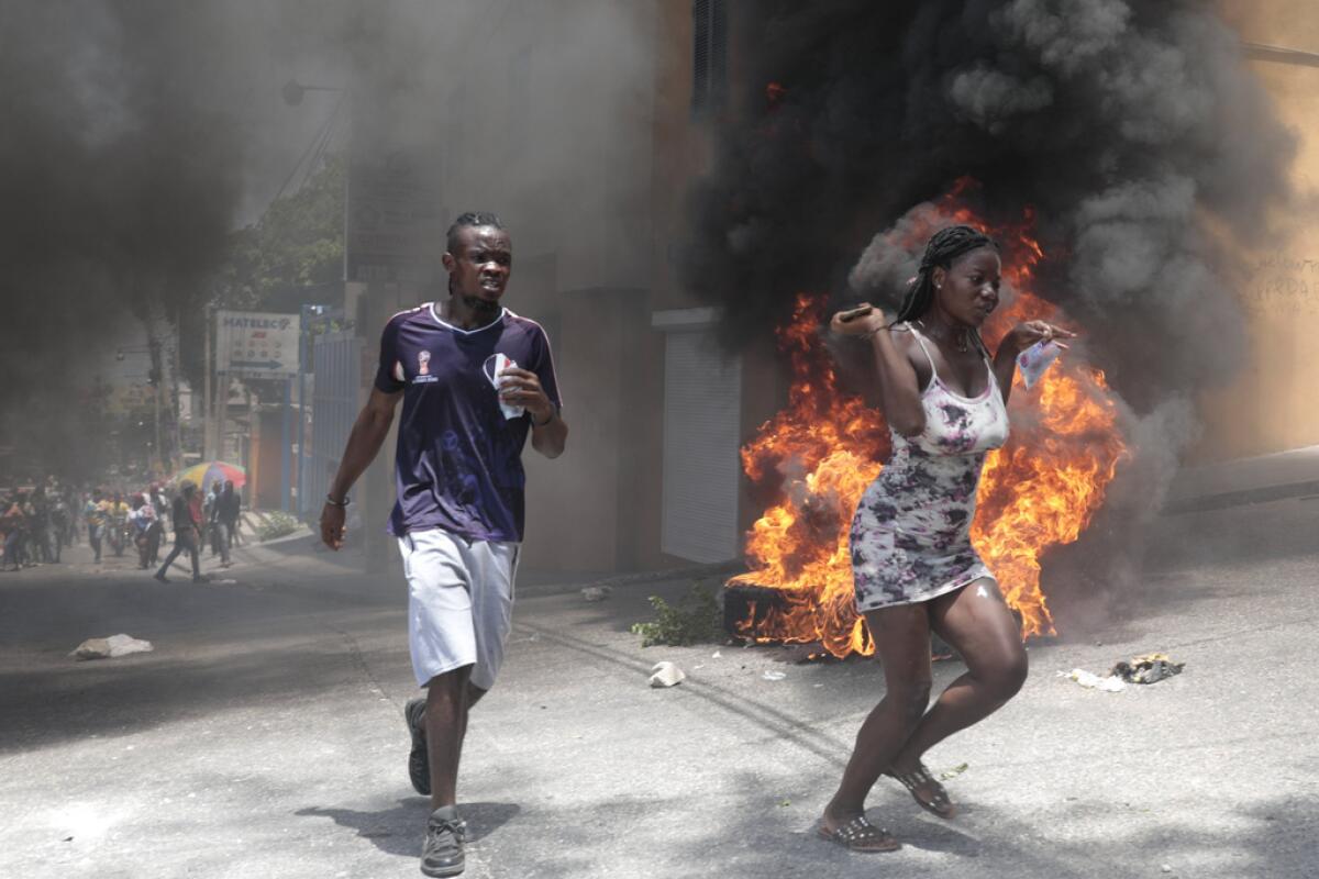 Manifestantes pasan corriendo junto a neumáticos incendiados