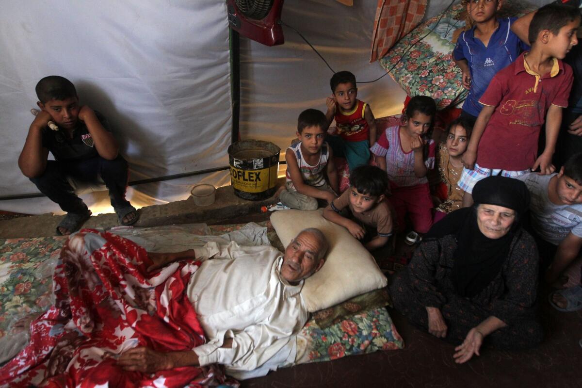 An Iraqi family that fled the city of Ramadi after it was seized by Islamic State militants gathers inside a tent at a camp for displaced families in Bzeibez outside Baghdad on Monday.