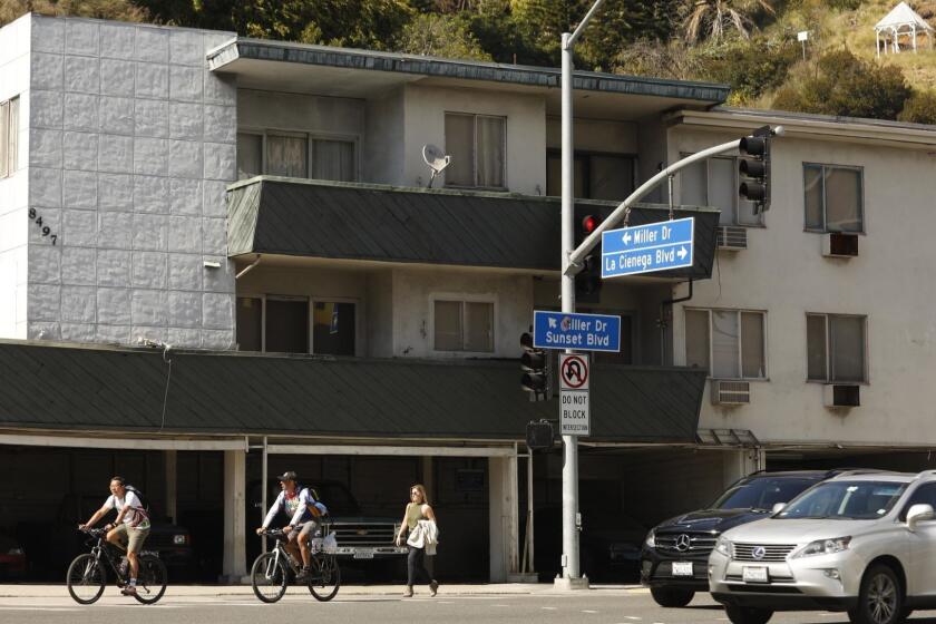 WEST HOLLYWOOD, CA - APRIL 25, 2018 - Pedestrians walk by 8497 Sunset Blvd. in West Hollywood on April 25, 2018. The structure, built in 1929, is soft story containing 30 residential units. The building is on West Hollywood's earthquake vulnerable list. There are about 800 buildings on the city's newly released list showing what buildings are possibly vulnerable in an earthquake and require study to determine if they must be retrofitted. (Genaro Molina / Los Angeles Times)