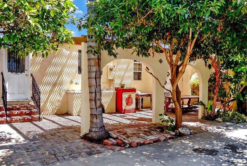 An arched entry leads to the brick patio outside a Spanish-style home