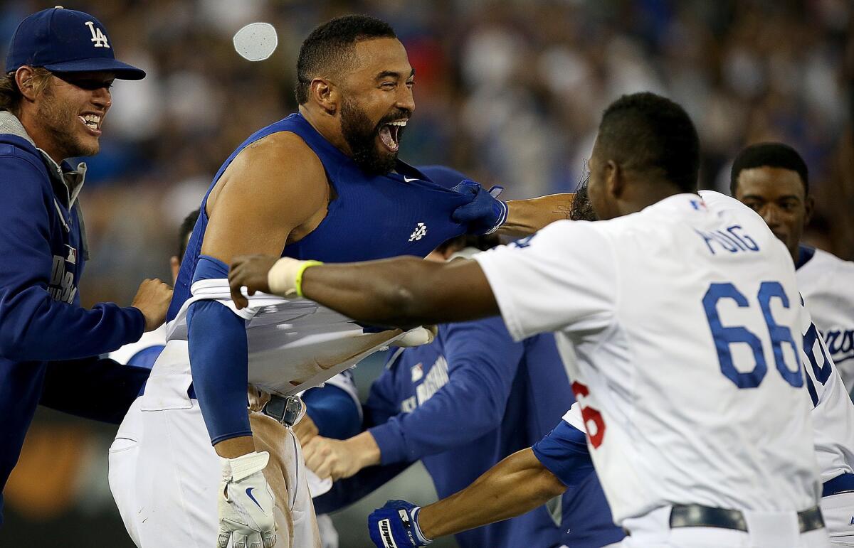 Dodgers right fielder Matt Kemp, center, celebrates with his teammates, including Clayton Kershaw, left, and Yasiel Puig, after driving in the winning run in the 12th inning of the Dodgers' 3-2 victory over the Atlanta Braves on Wednesday.