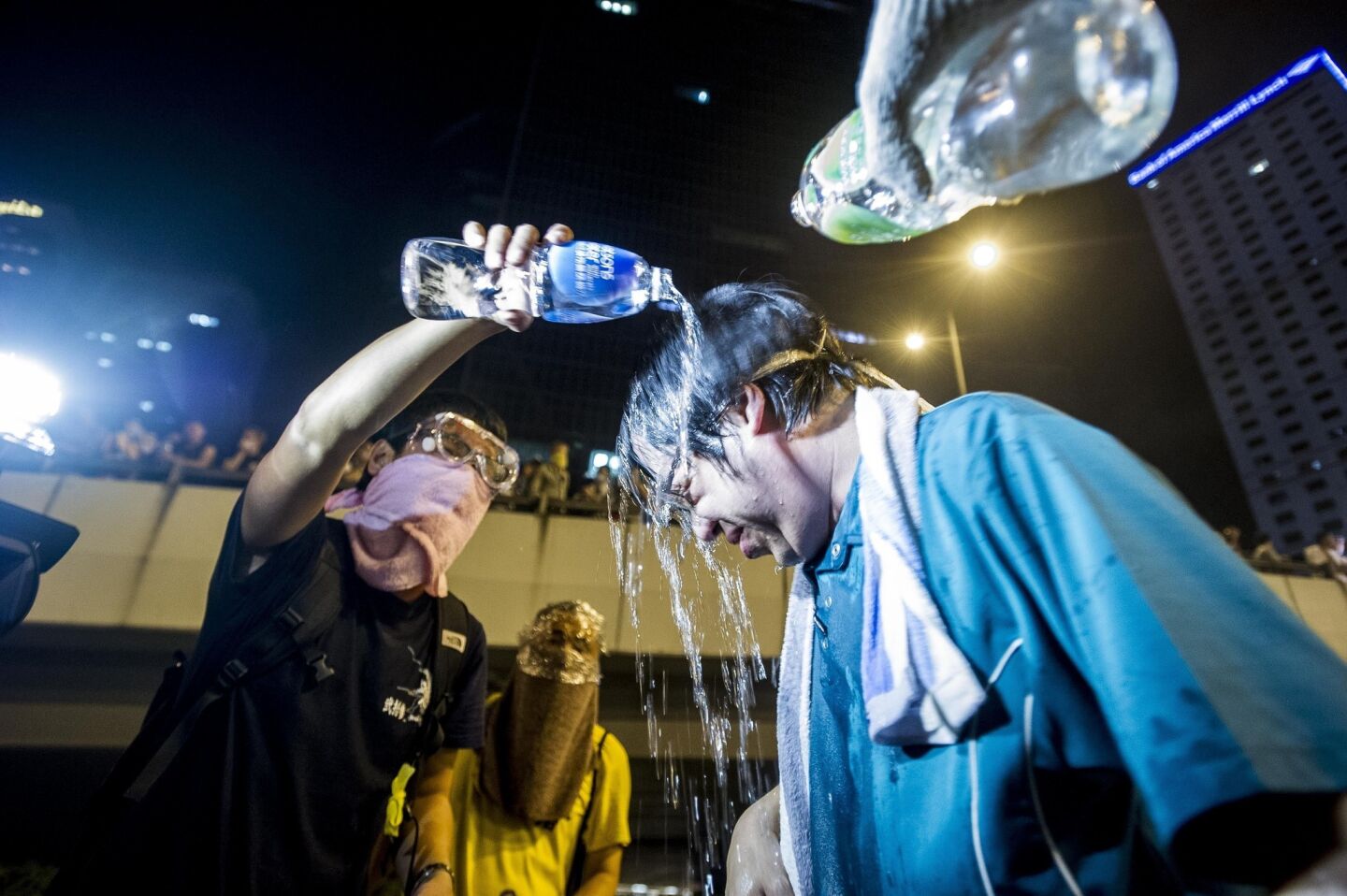 Protesters pour water over the head of a fellow demonstrator during riots that followed a pro-democracy protest on Sept. 28, 2014.