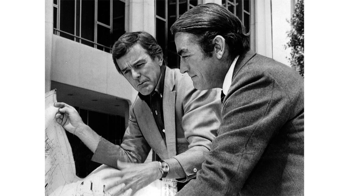 Actor Gregory Peck, right, and director-choreographer Gower Champion look over a floor plan of the Dorothy Chandler Pavilion of the Music Center.