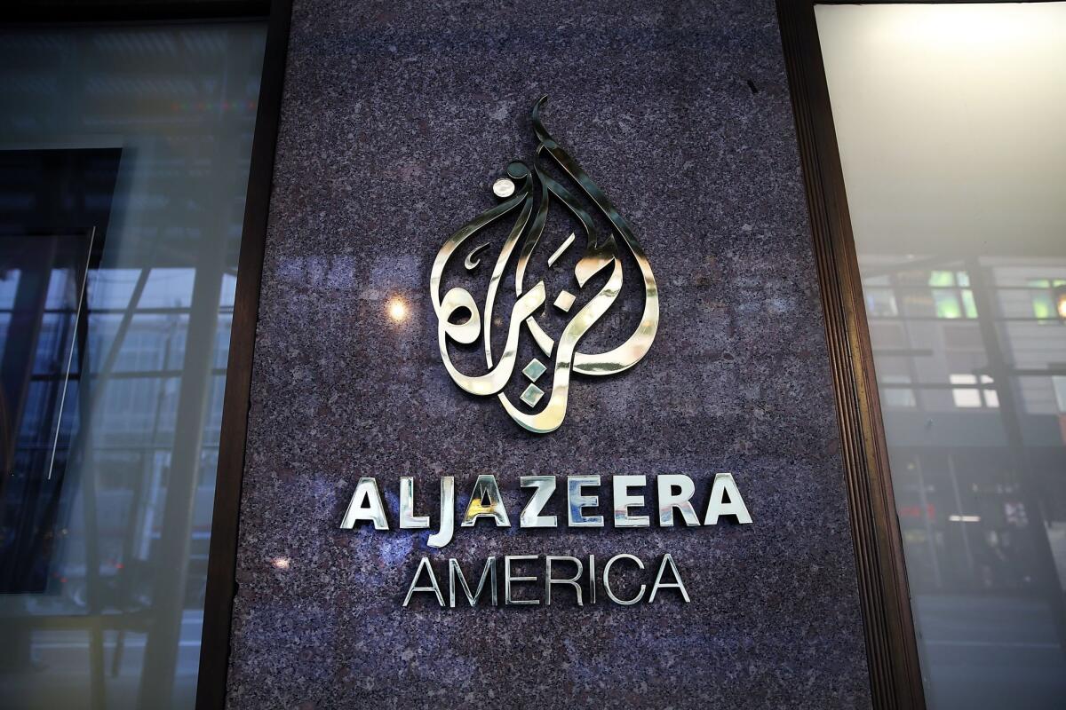 The logo for Al Jazeera America is displayed outside of the cable news channel's offices on Jan. 13 in New York City. The company, which debuted in August 2013, announced it is shutting down.