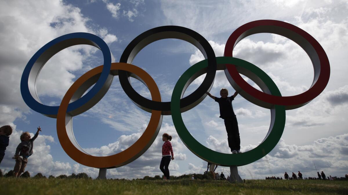 Children play on an Olympic rings display near the rowing venue for the 2012 London Olympic Games.