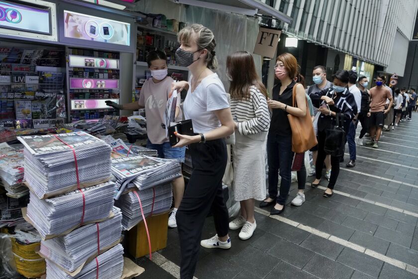 People queue up for last issue of Apple Daily at a newspaper booth at a downtown street in Hong Kong, Thursday, June 24, 2021. Across Hong Kong, people lined up early Thursday to buy the last print edition of the last remaining pro-democracy newspaper. ( AP Photo/Vincent Yu)