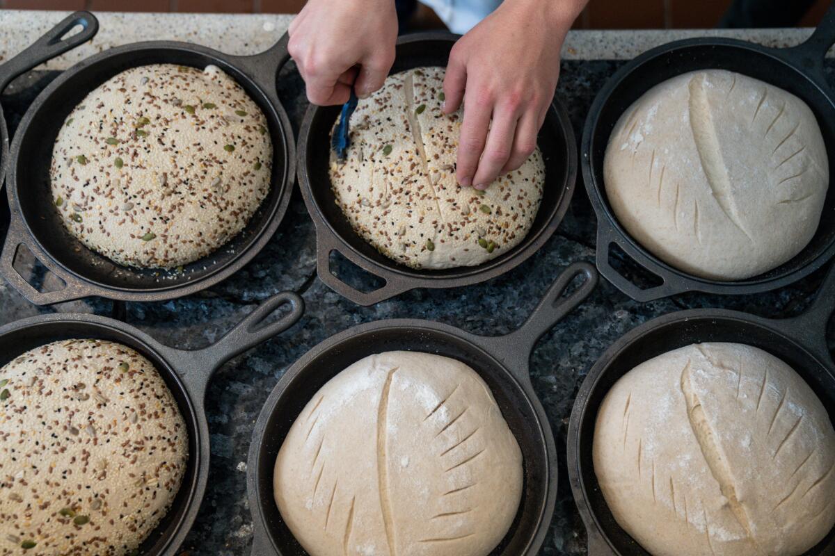 Jyan Isaac Horwitz scores sourdough bread that's ready to go into the oven.